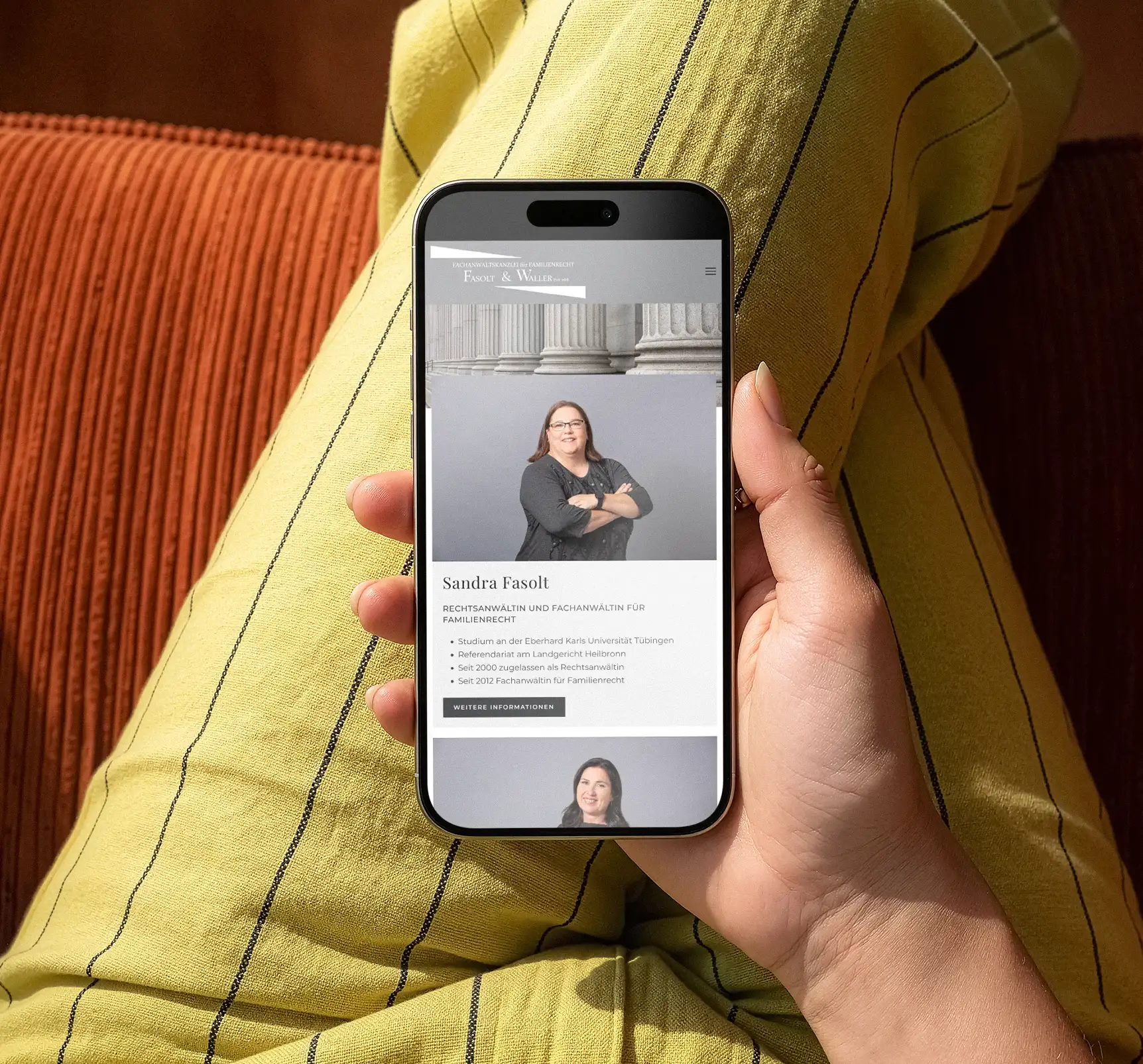 Frau sitzt auf Sofa und bucht Termin über Smartphone